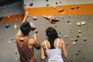 photo of man and woman standing in front of climbing wall