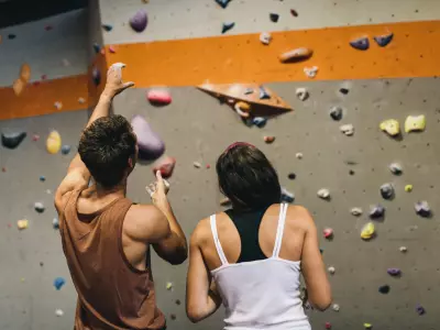 photo of man and woman standing in front of climbing wall